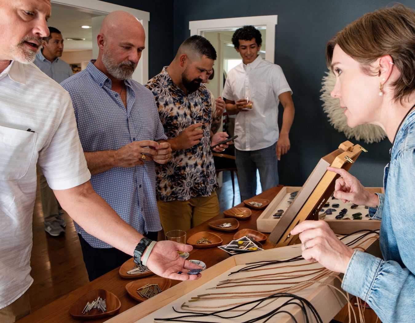 Guests selecting bolo tie slides, cords, and tips at a Build Your Own Bolo corporate event in Austin