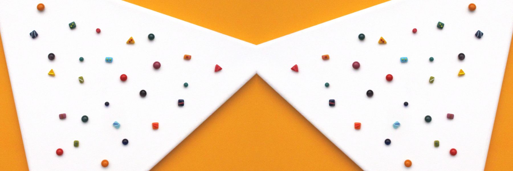 Colorful handmade fused glass studs scattered on white with bold orange geometric frame