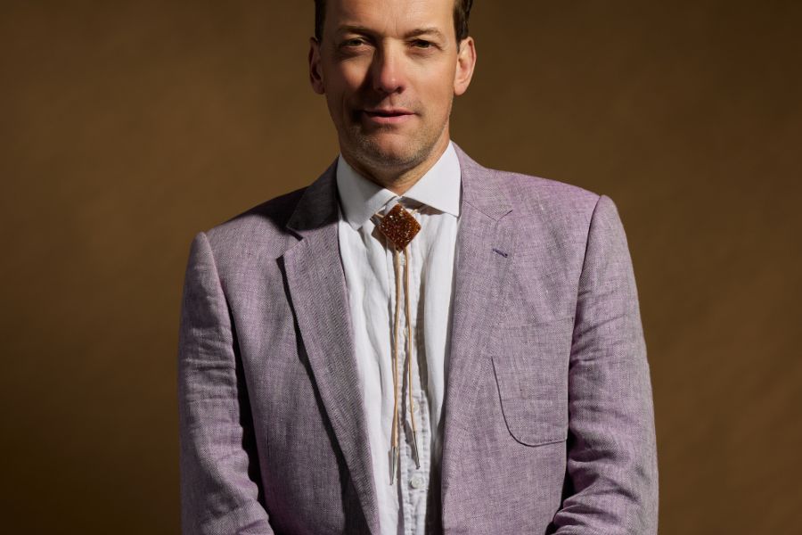 Man wearing stone bolo tie with lavender suit formal styling