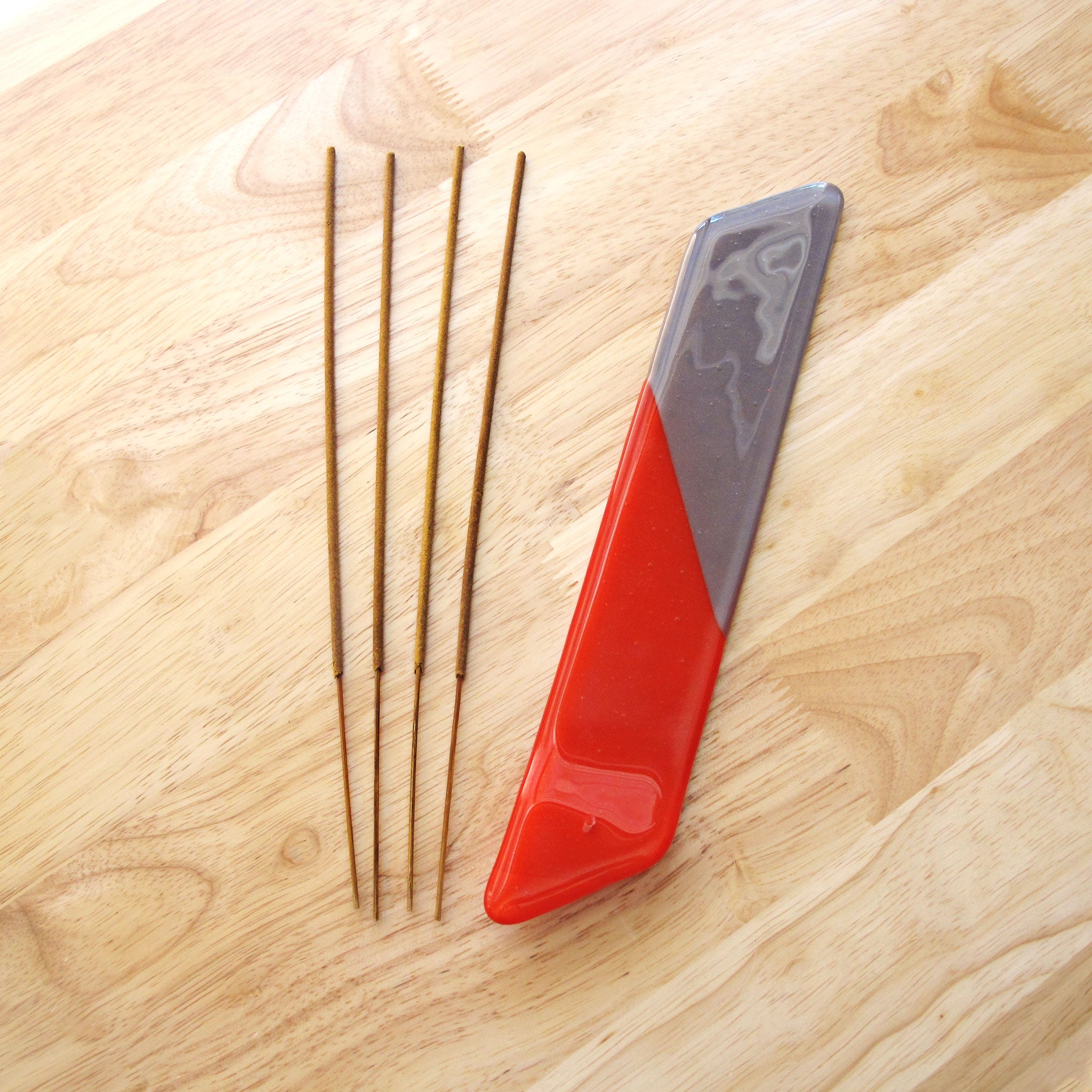 Katie Kismet red and gray incense burner with four sticks of incense (flat view)
